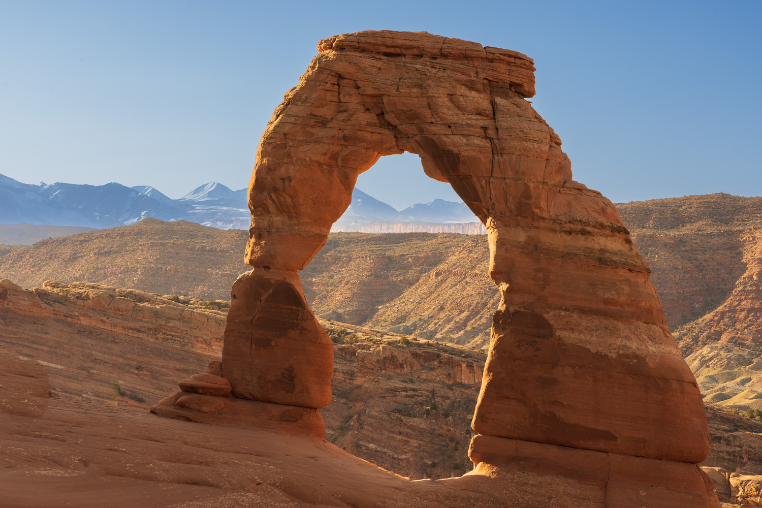 Sandstone arch with mountains in the background